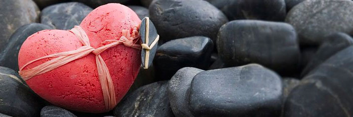 Een hartvormige rots in een bed van rotsen - Alles Over Liefde Banier